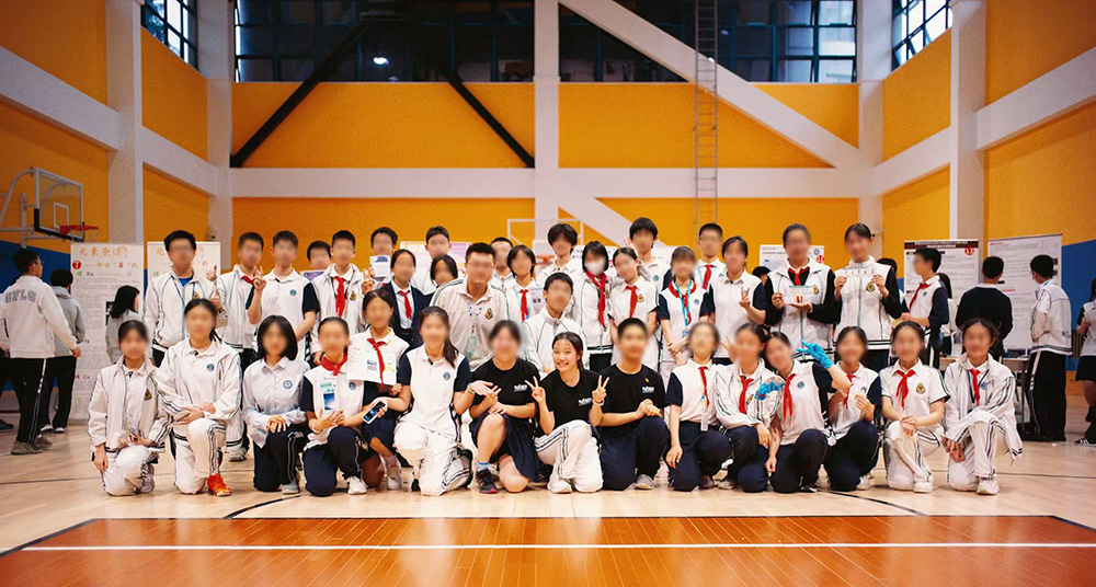 A group of students wearing a school uniform posing in a gymnasium
