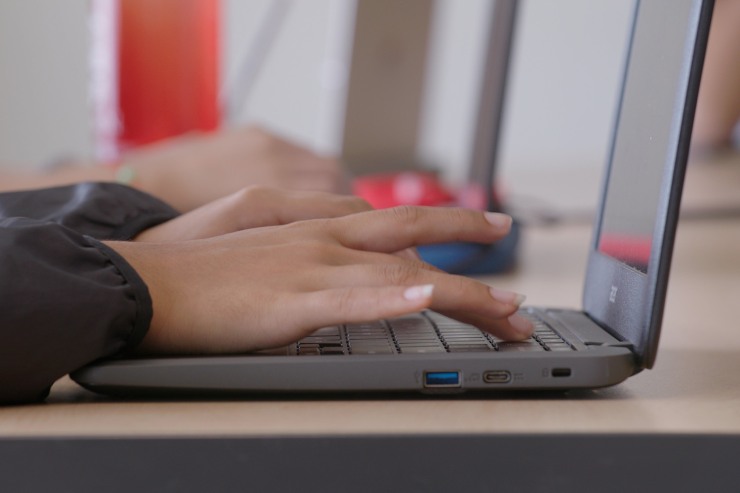 Hands typing on a laptop keyboard