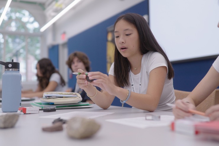 student studying a rock
