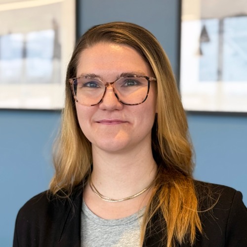 Headshot of Maya Ahlstrom in front of a blue wall