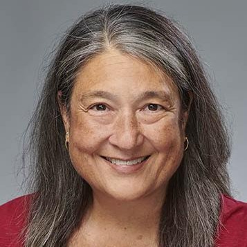 Headshot of Kisa Takesue in front of a grey background