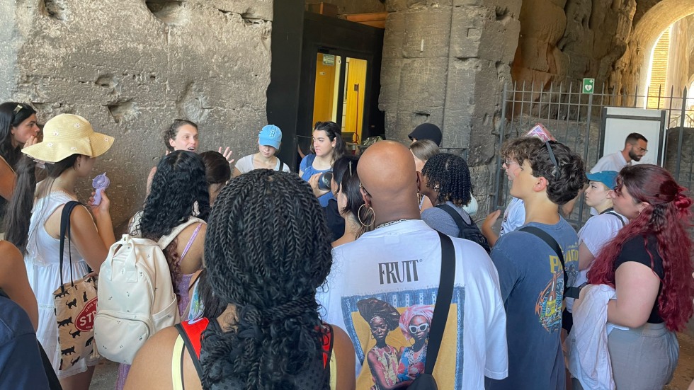 students being led by a tour guide through a Roman building