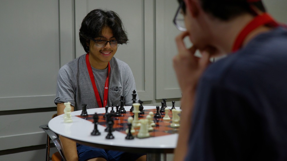 two students playing chess together