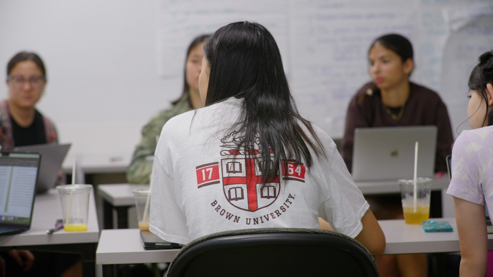 students having a class discussion in class, with a student in a Brown University t-shirt in the foreground