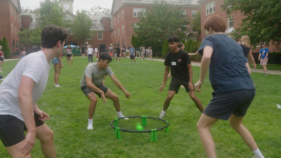 Four students playing a lawn game at Brown University