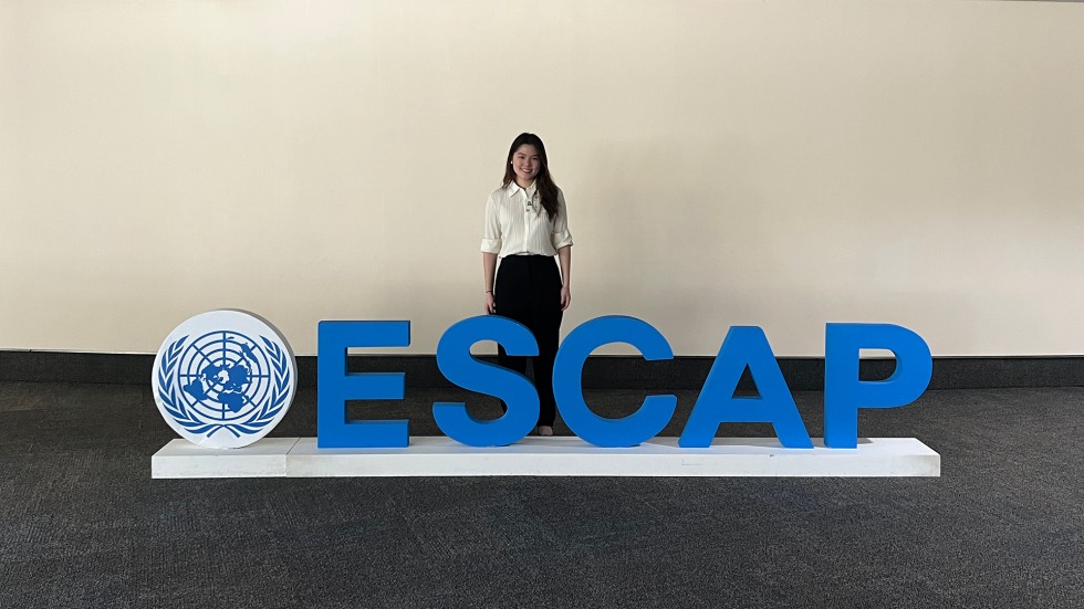 Gracelyn Atmadja stands beside a sign that reads "ESCAP"