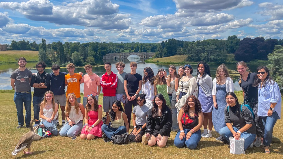 group of students posing as a group in front of a pond