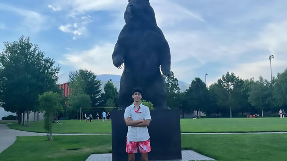 Yusuf standing in front of the Bruno statue at Brown Unversity