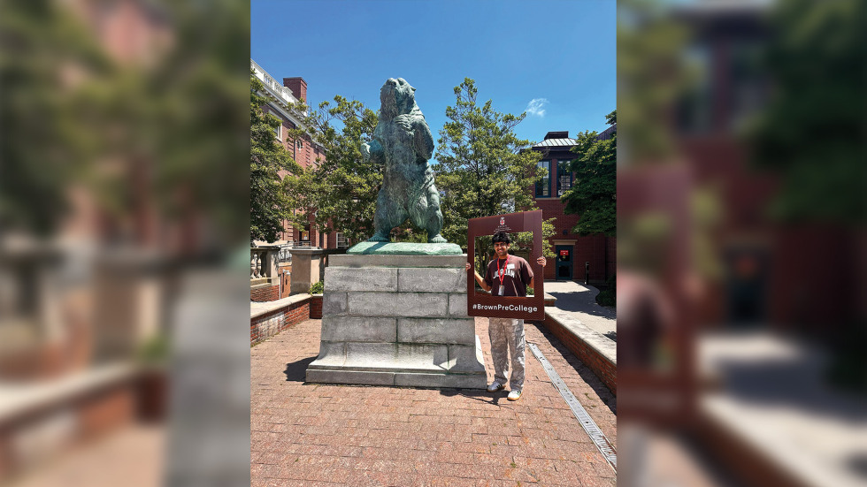 Pradyu standing beside a Bruno statue holding a selfie frame