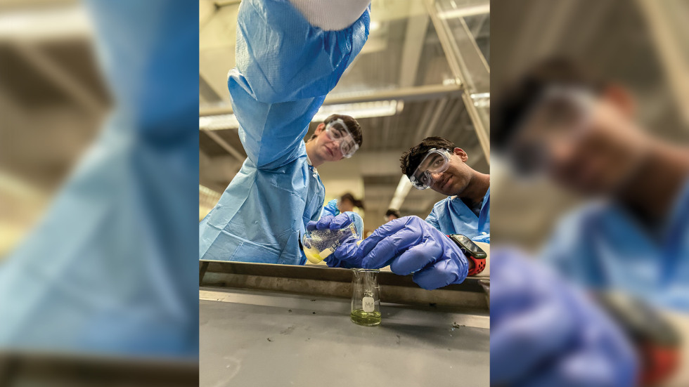 two boys in a science class wearing lab gear