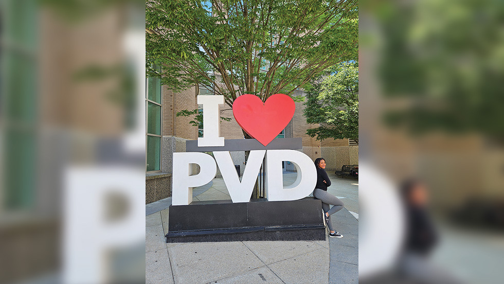 Brielle posing on a sign that says "I heart PVD"