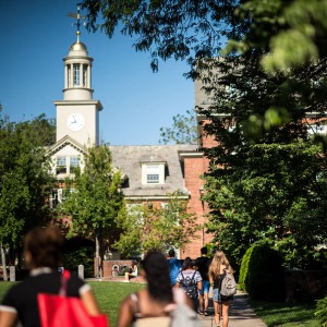 Students walking in front of a Brown campus building in the summer.
